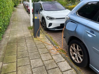 Modern electric car charging on city street