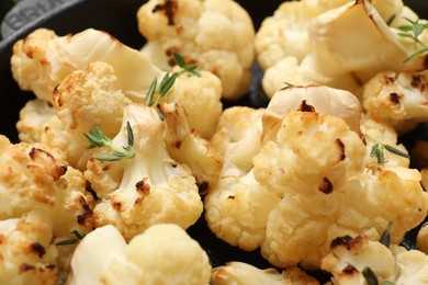 Photo of Tasty baked cauliflower with thyme in baking pan, closeup