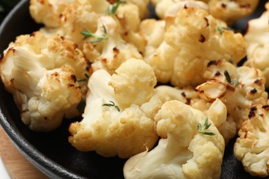 Photo of Tasty baked cauliflower with thyme in baking pan, closeup