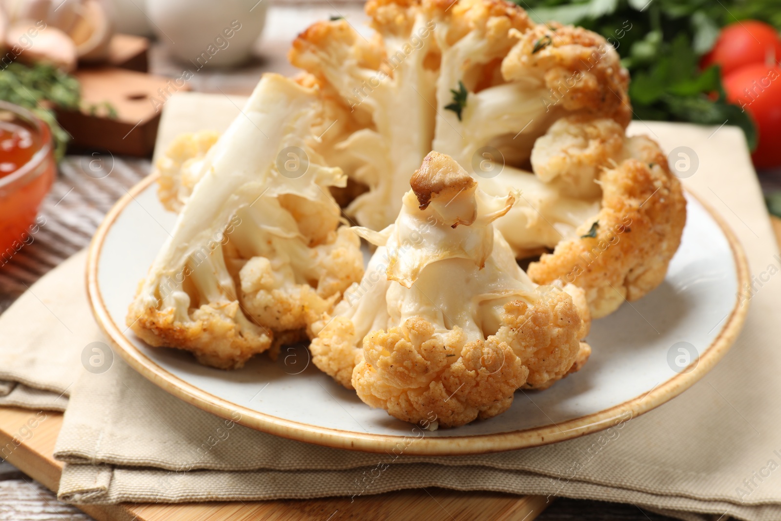 Photo of Plate with tasty baked cauliflower on table, closeup