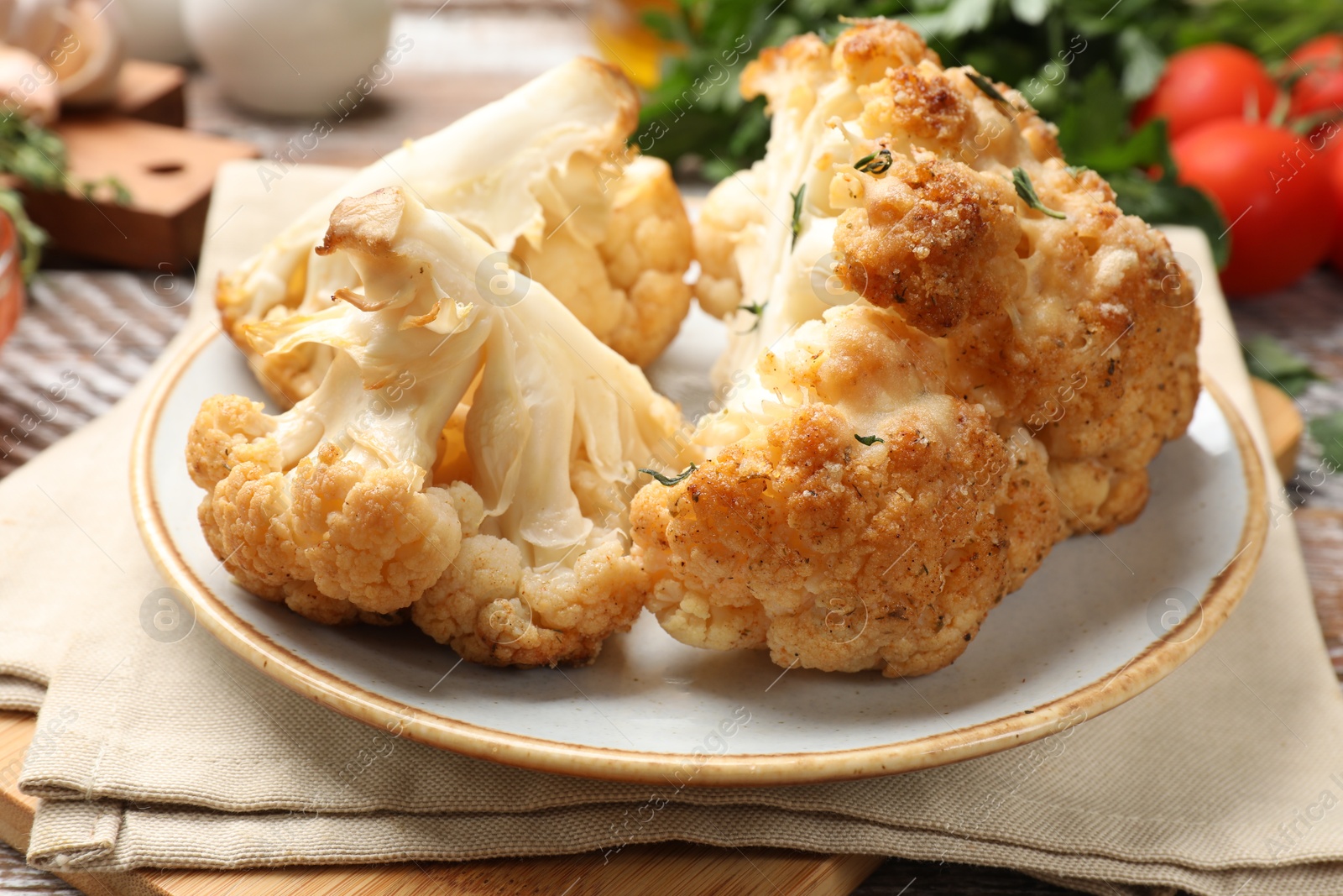 Photo of Plate with tasty baked cauliflower on table, closeup