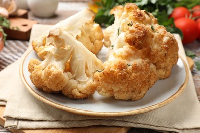 Plate with tasty baked cauliflower on table, closeup