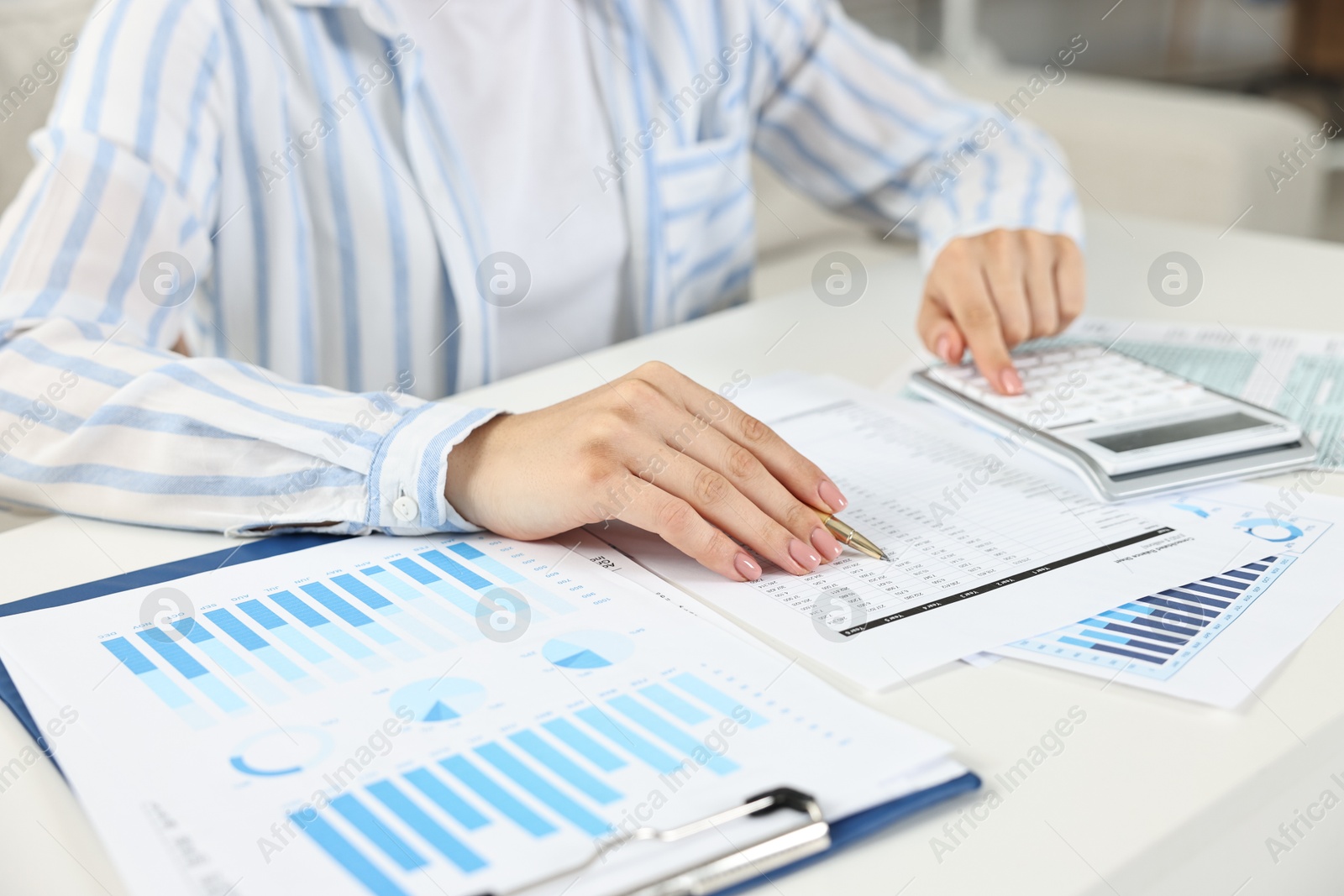 Photo of Budget planning. Woman with papers and calculator at white table, closeup