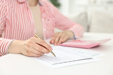 Budget planning. Woman with papers at white table, closeup