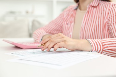 Photo of Budget planning. Woman with papers at white table, closeup