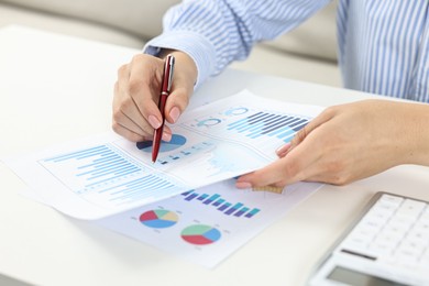 Budget planning. Woman with papers at white table, closeup