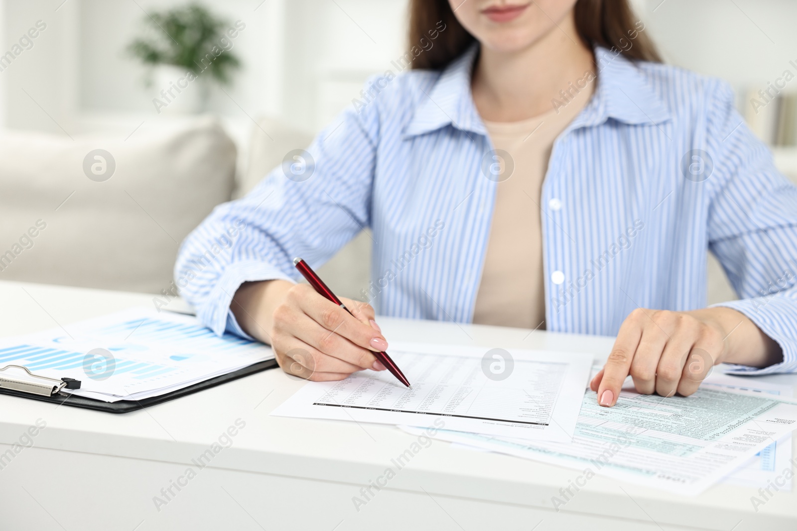 Photo of Budget planning. Woman with papers at white table, closeup