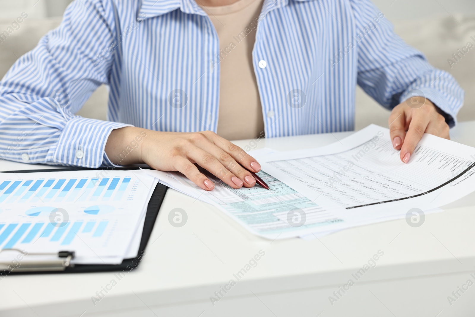 Photo of Budget planning. Woman with papers at white table, closeup