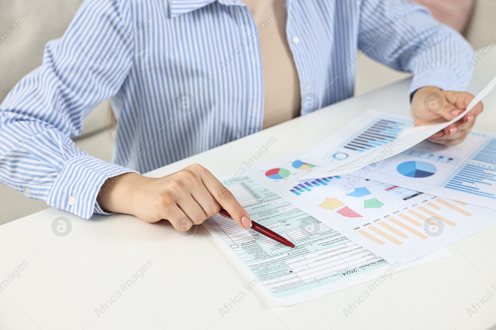 Photo of Budget planning. Woman with papers at white table, closeup