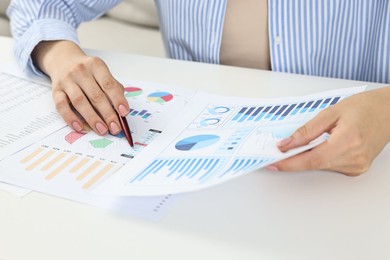 Budget planning. Woman with papers at white table, closeup