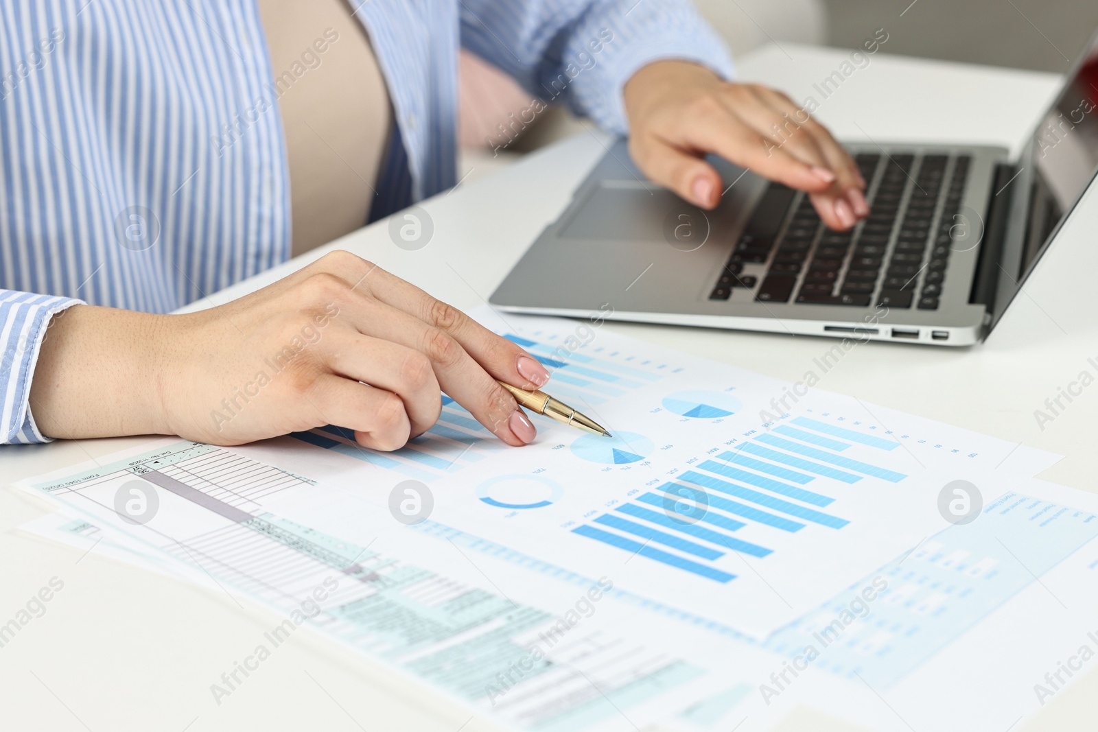 Photo of Budget planning. Woman with papers using laptop at white table, closeup