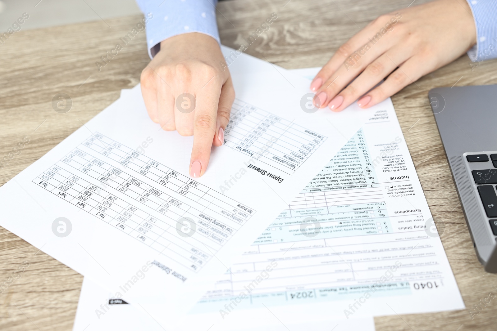 Photo of Budget planning. Woman with papers at wooden table, closeup