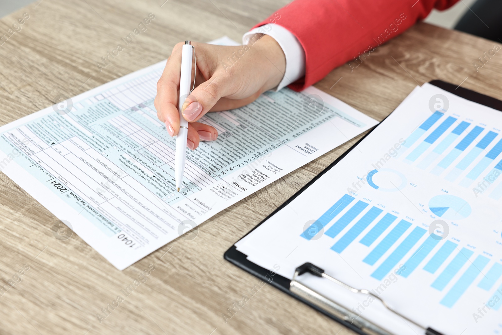 Photo of Budget planning. Woman with papers at wooden table, closeup