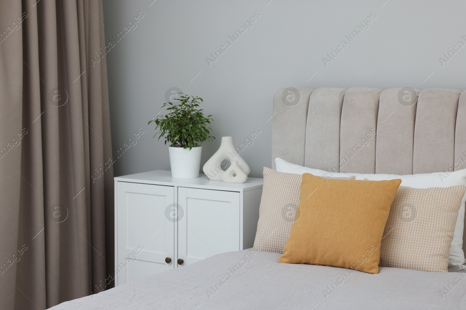 Photo of Different soft pillows on bed in room