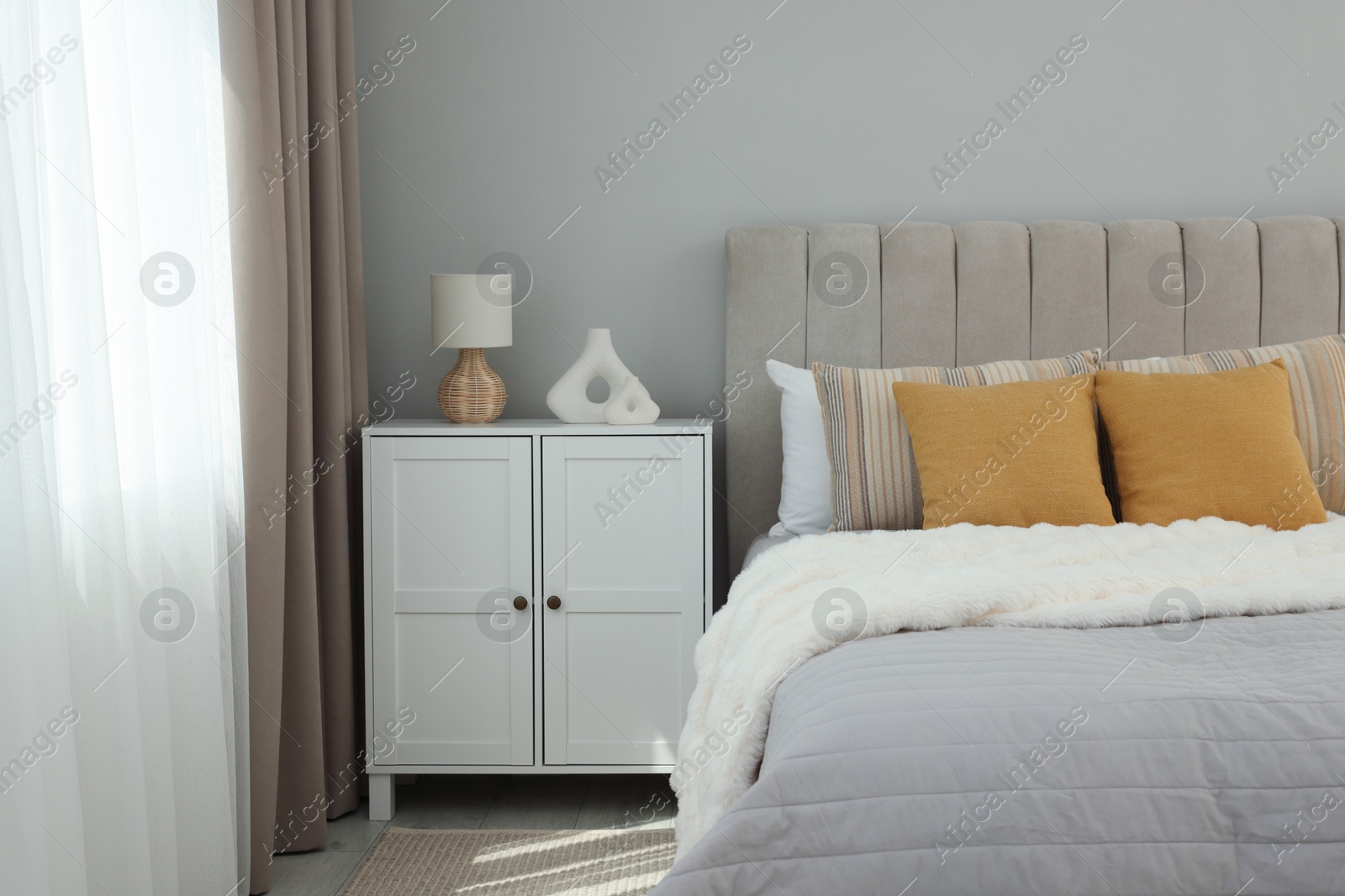 Photo of Different soft pillows on bed in room