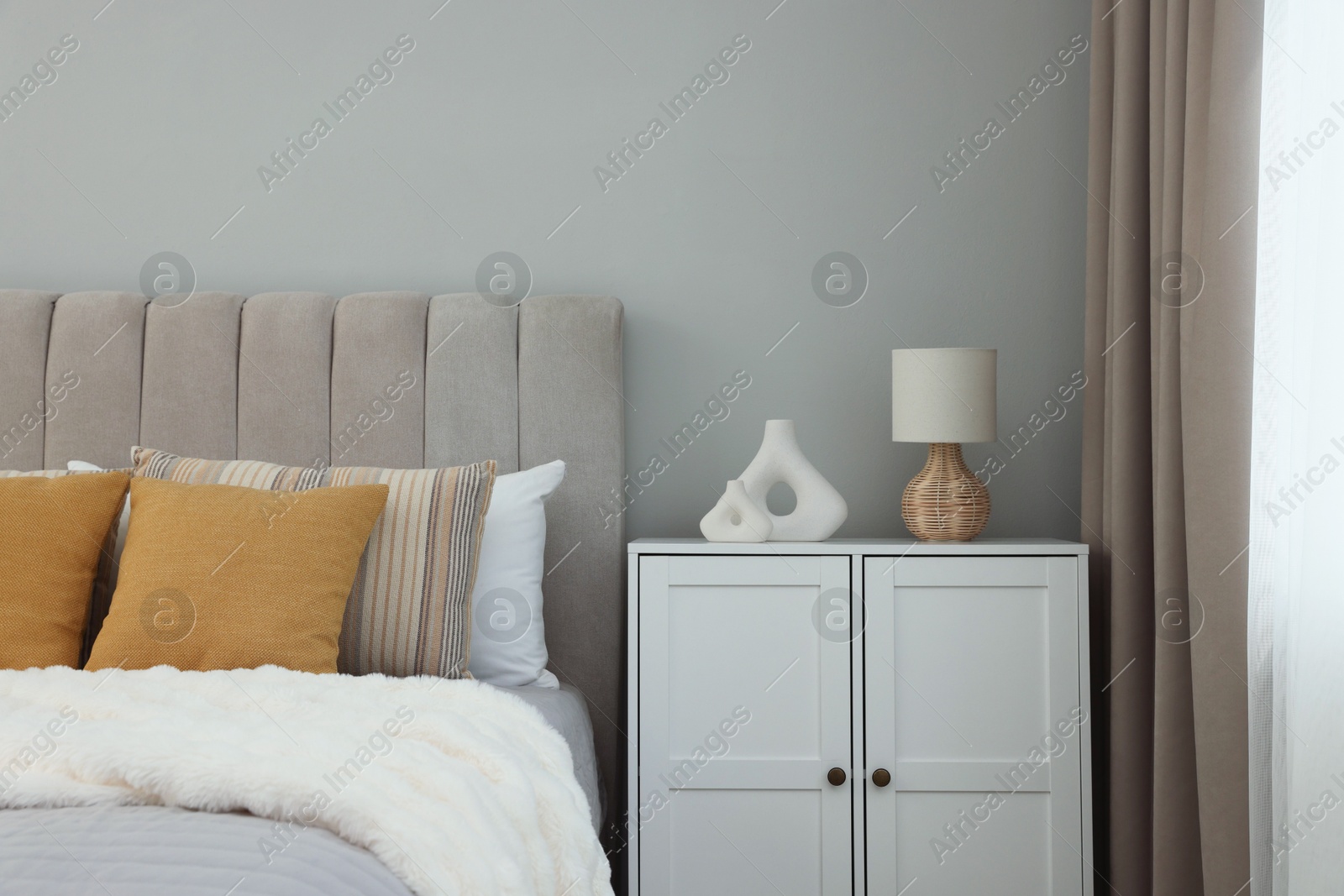 Photo of Different soft pillows on bed in room