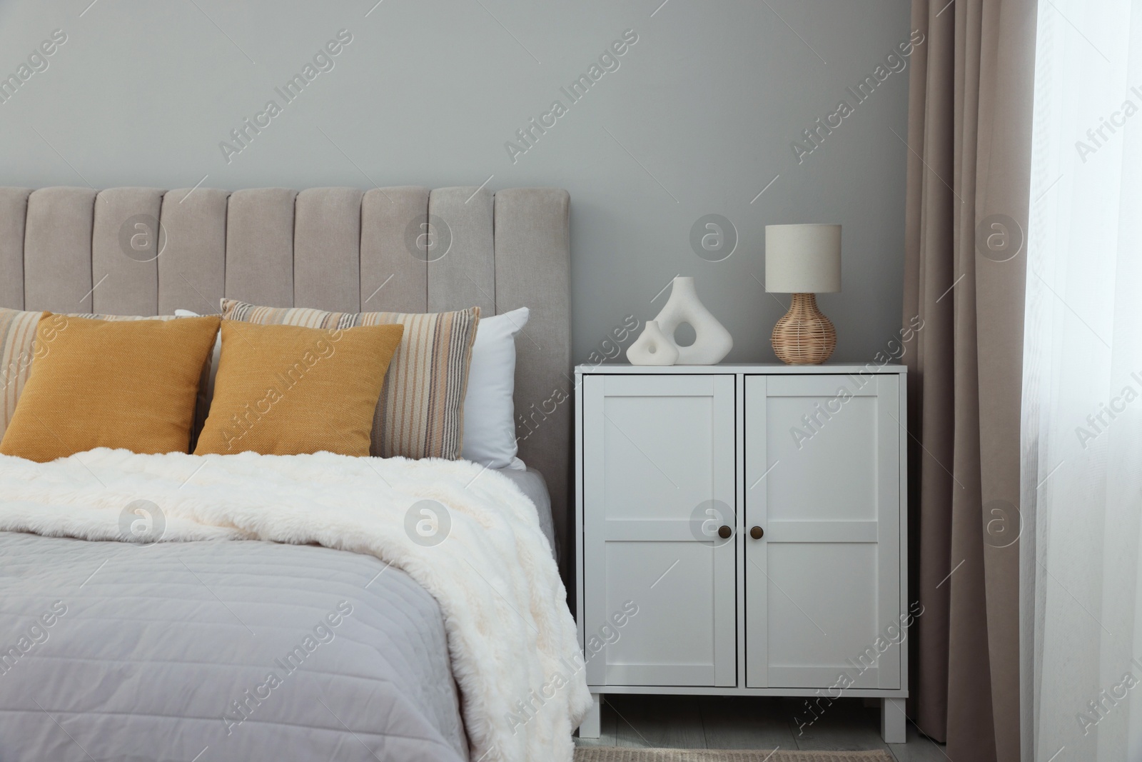 Photo of Different soft pillows on bed in room