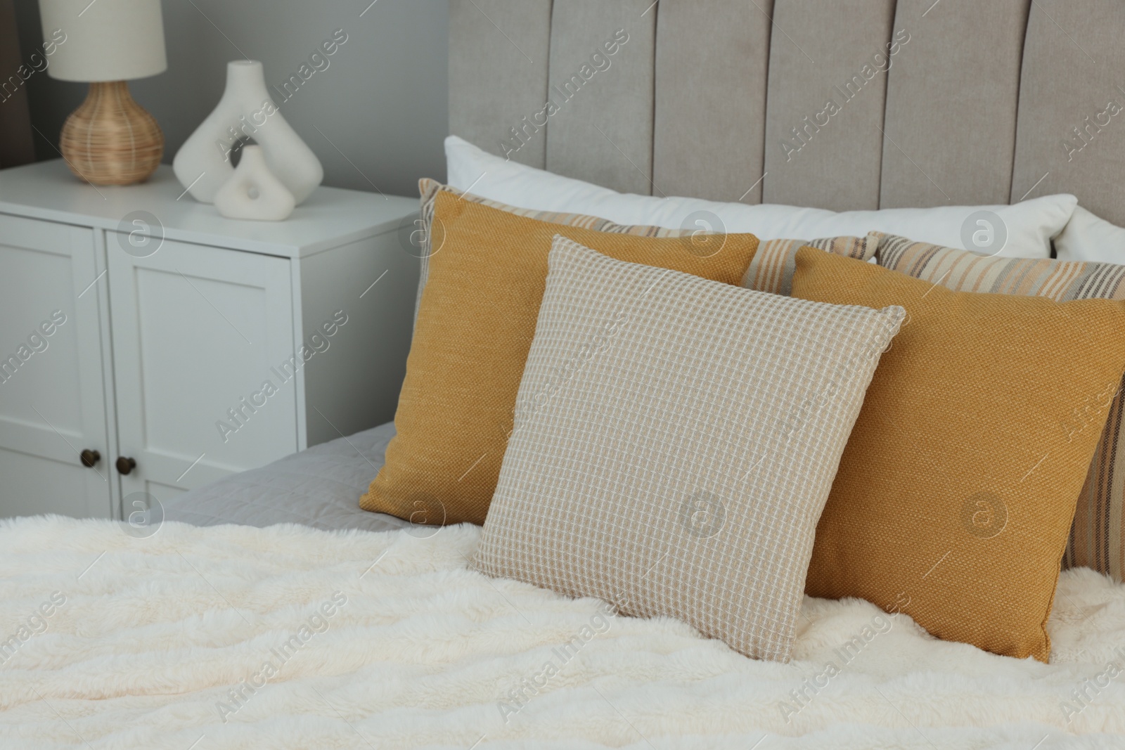 Photo of Different soft pillows on bed in room