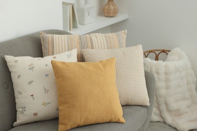 Photo of Different soft pillows on sofa in room