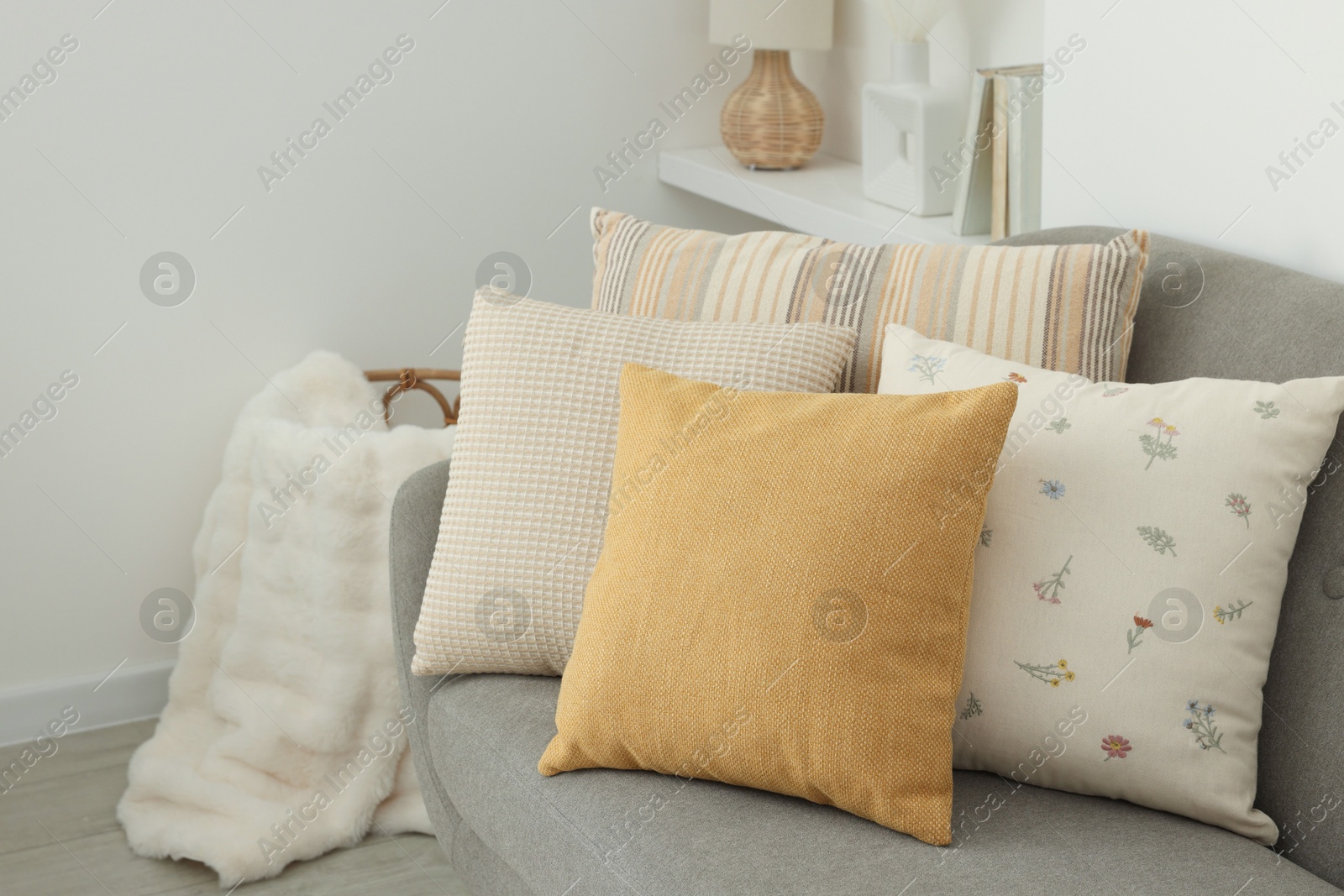 Photo of Different soft pillows on sofa in room