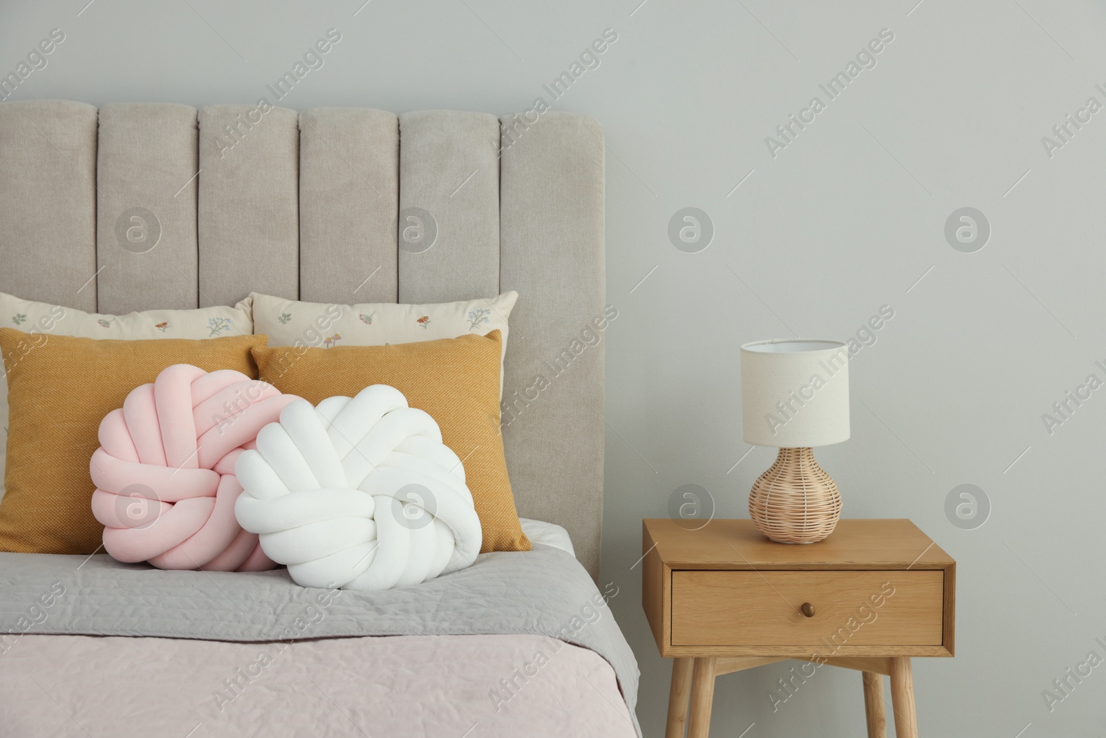 Photo of Different soft pillows on bed in room