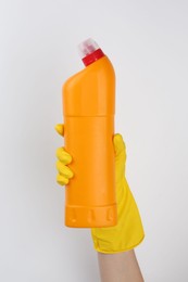 Photo of Woman holding toilet cleaner in bottle on light background, closeup