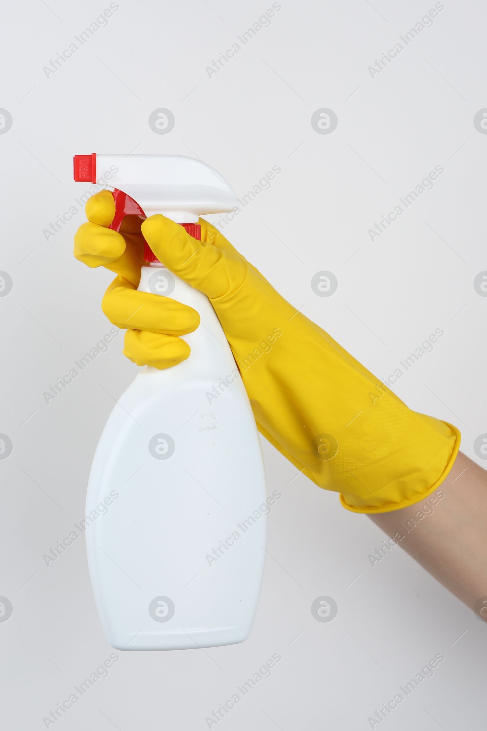 Photo of Woman holding toilet cleaner in spray bottle on light background, closeup