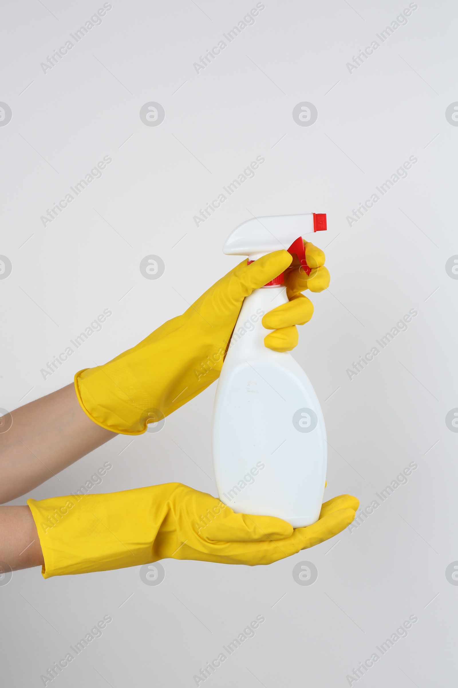 Photo of Woman holding toilet cleaner in spray bottle on light background, closeup