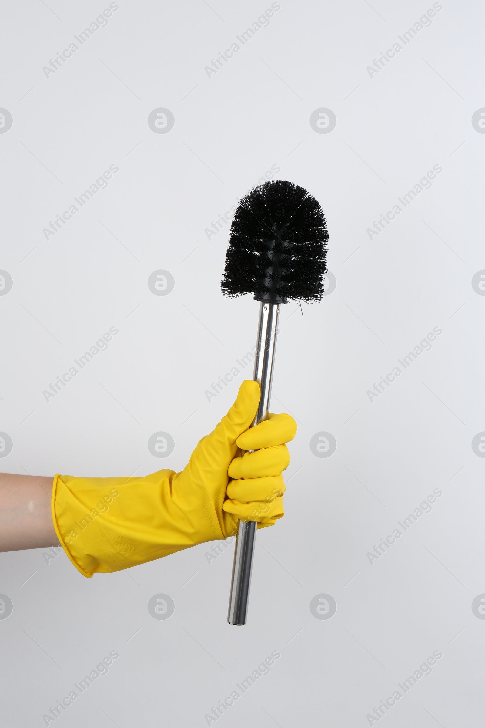 Photo of Woman holding black toilet brush on light background, closeup. Cleaning tool