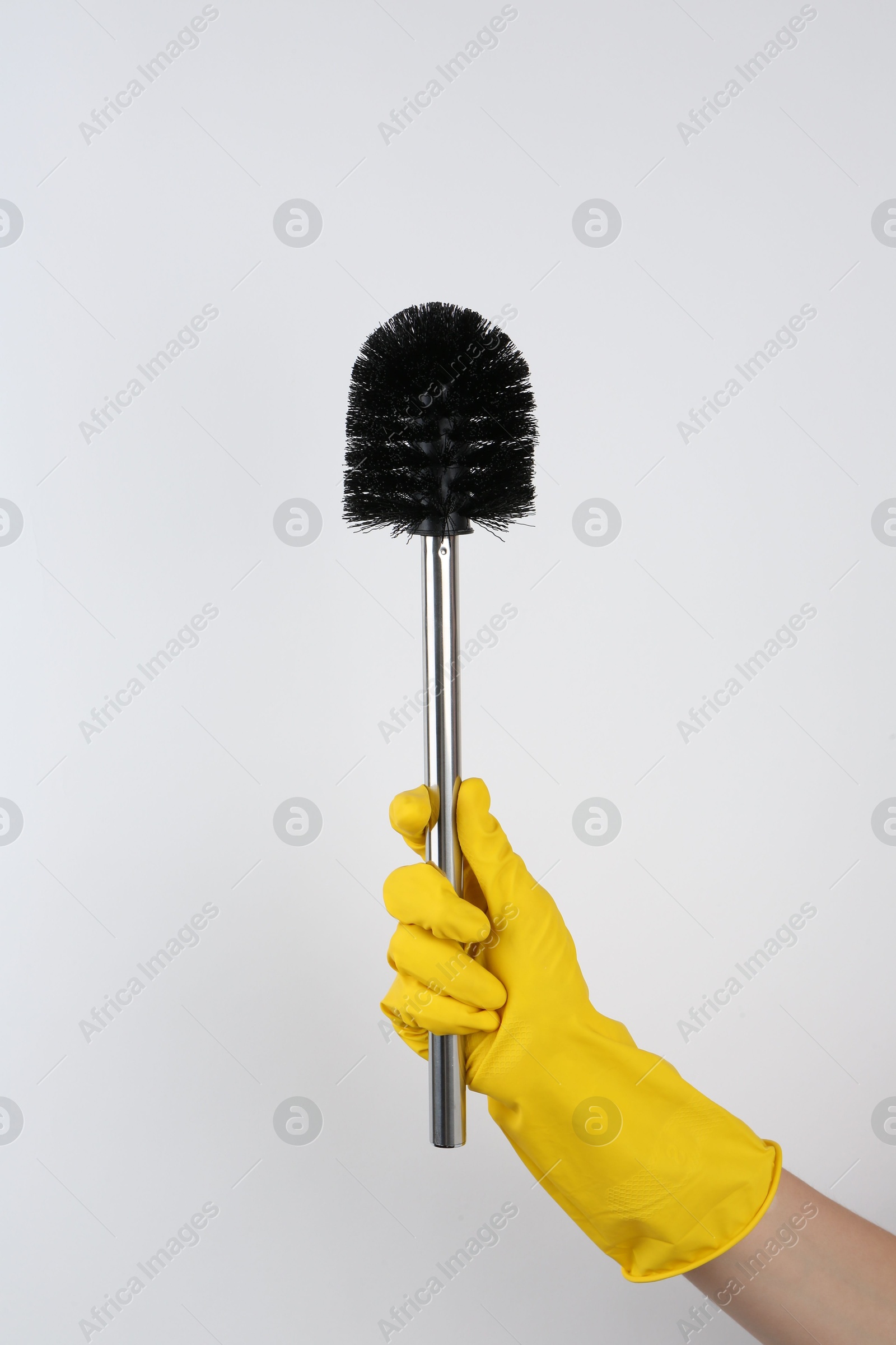 Photo of Woman holding black toilet brush on light background, closeup. Cleaning tool