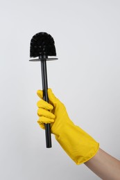 Photo of Woman holding black toilet brush on light background, closeup. Cleaning tool