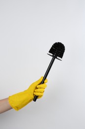 Photo of Woman holding black toilet brush on light background, closeup. Cleaning tool