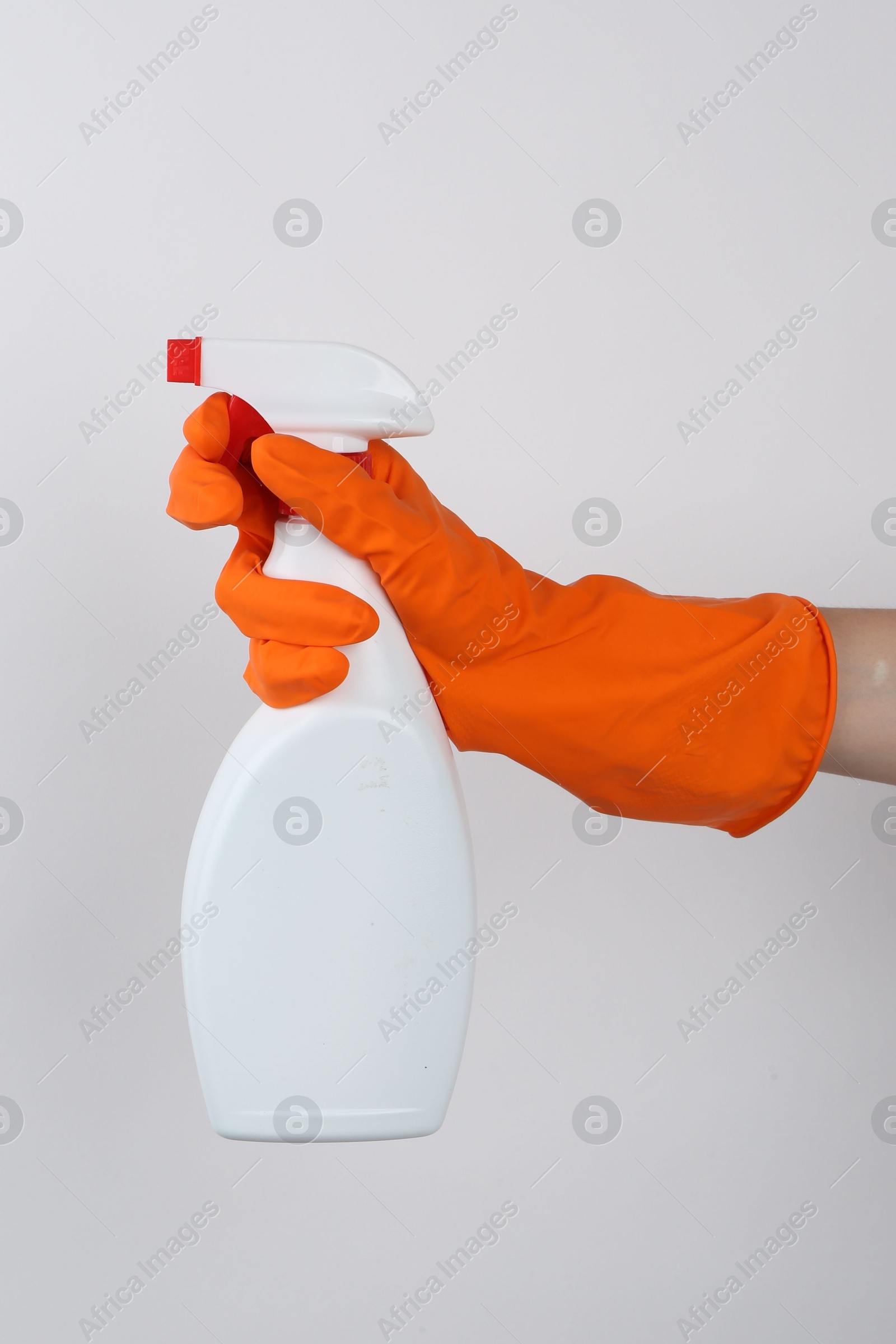 Photo of Woman holding toilet cleaner in spray bottle on light background, closeup