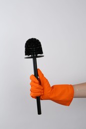 Photo of Woman holding black toilet brush on light background, closeup. Cleaning tool