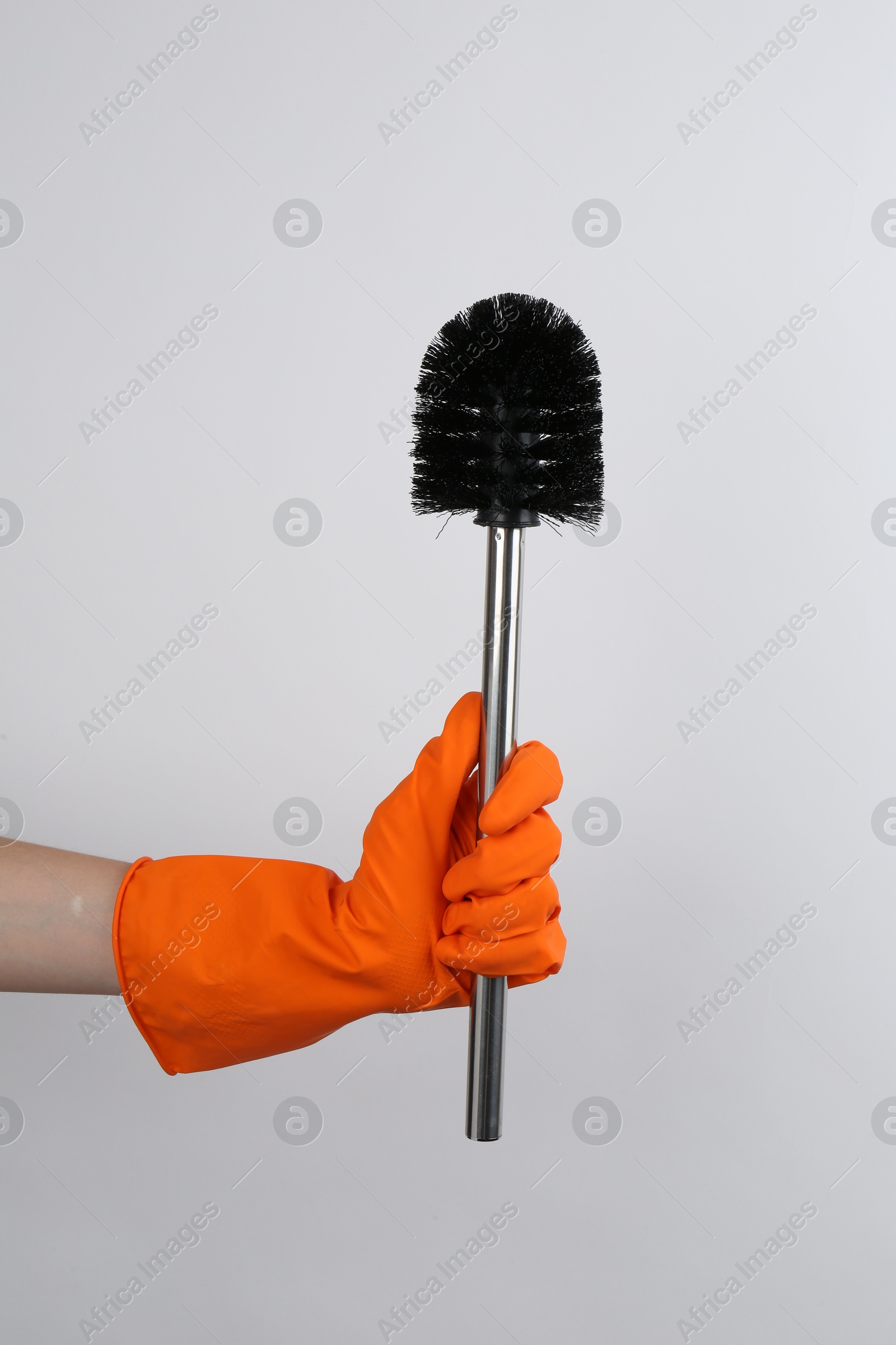 Photo of Woman holding black toilet brush on light background, closeup. Cleaning tool