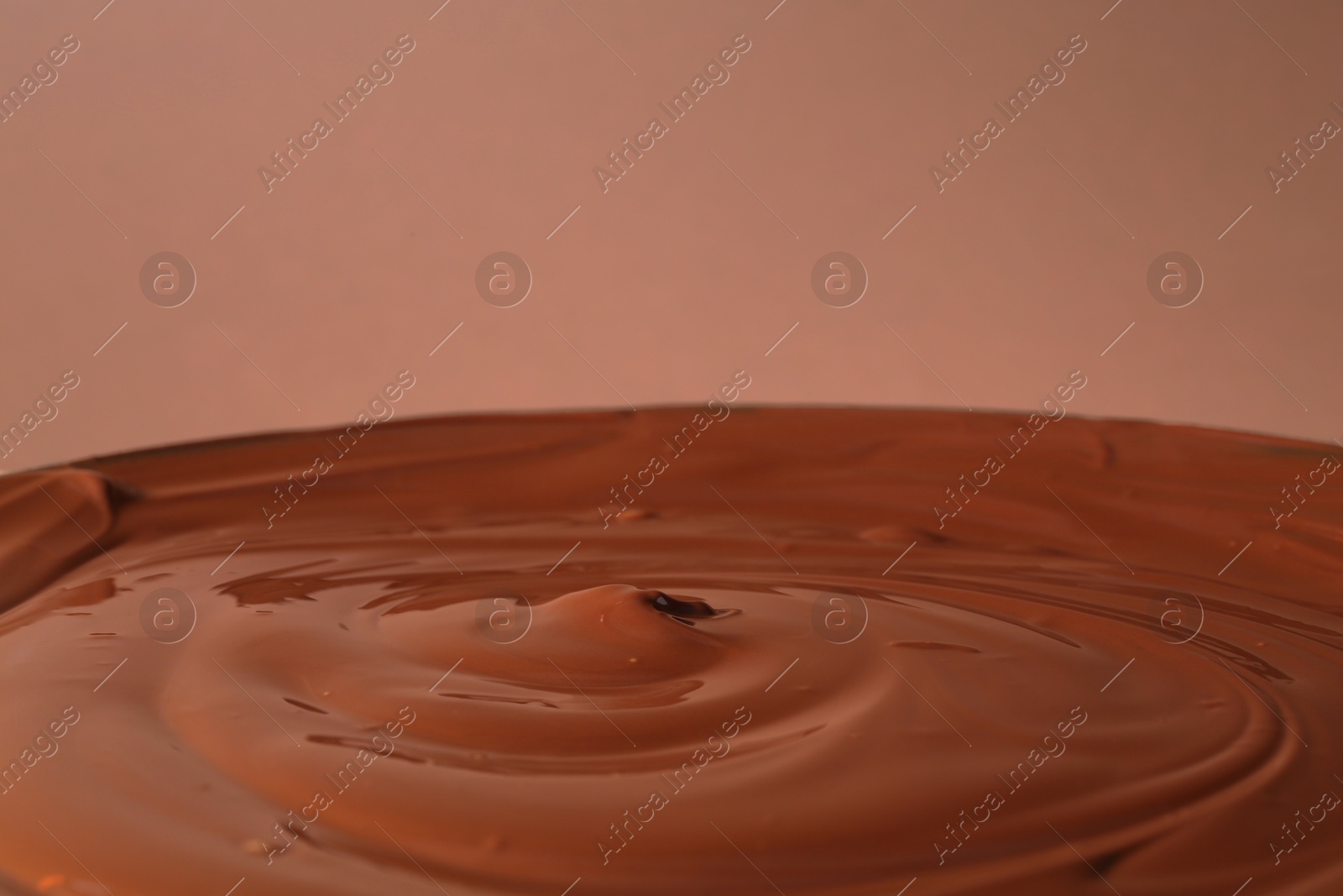 Photo of Delicious melted chocolate on brown background, closeup