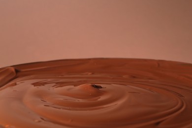 Photo of Delicious melted chocolate on brown background, closeup