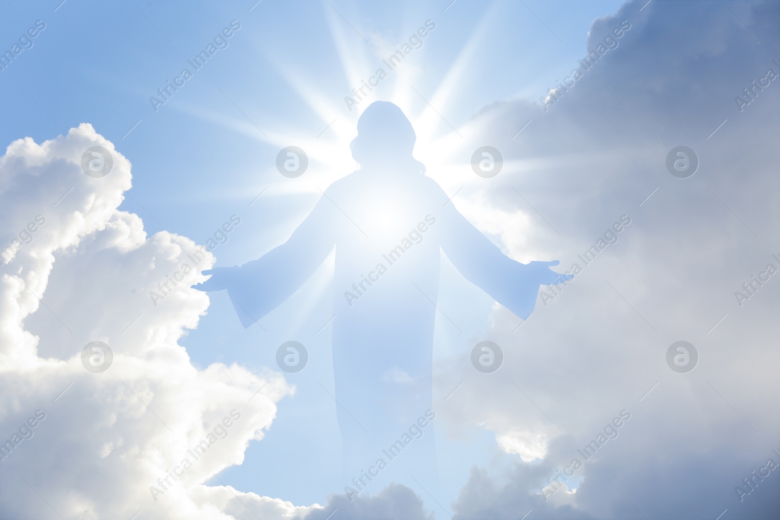 Image of Silhouette of Jesus Christ in sunlight among clouds in sky