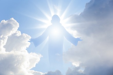 Image of Silhouette of Jesus Christ in sunlight among clouds in sky