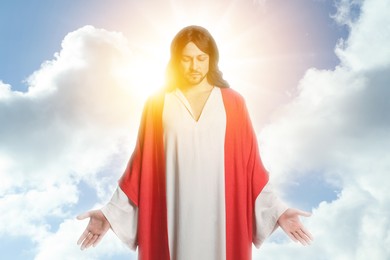 Jesus Christ in sunlight among clouds in sky