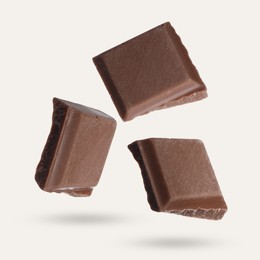 Image of Pieces of sweet chocolate falling on beige background