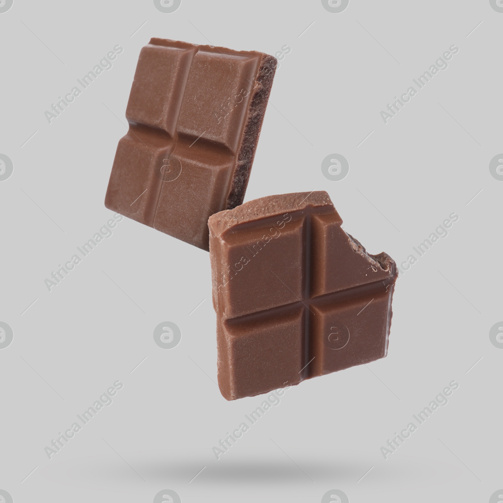 Image of Pieces of sweet chocolate falling on grey background