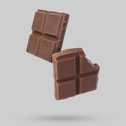 Image of Pieces of sweet chocolate falling on grey background