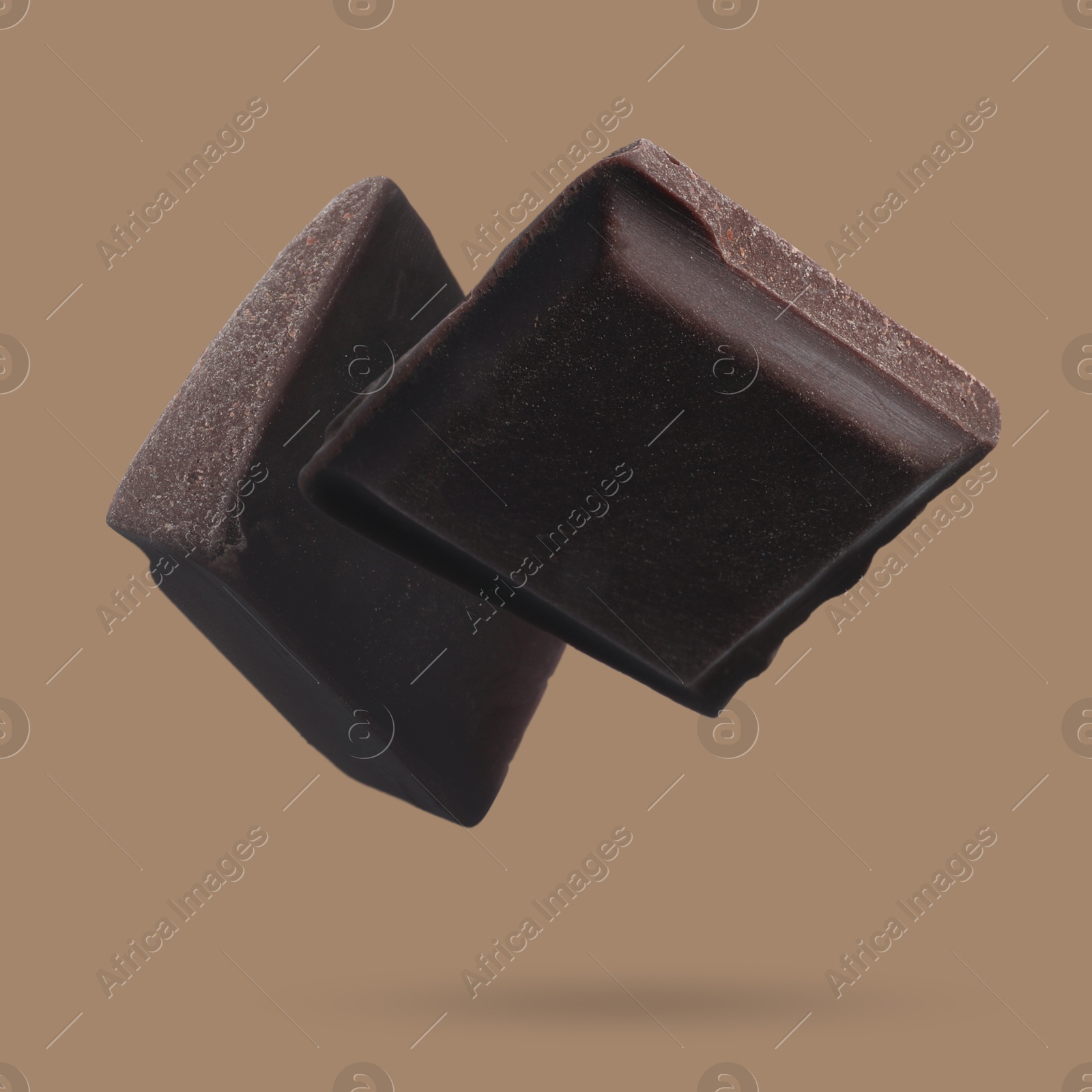 Image of Pieces of sweet chocolate falling on color background