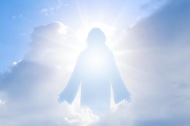 Image of Silhouette of Jesus Christ in sunlight among clouds in sky