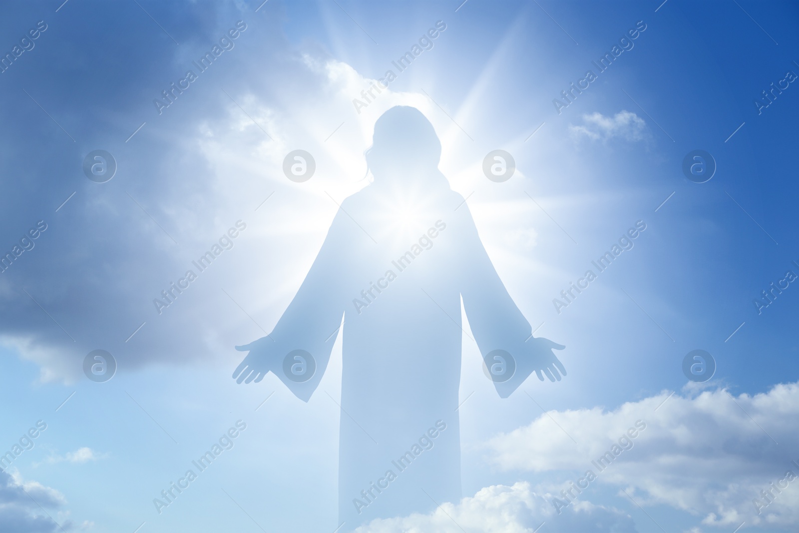 Image of Silhouette of Jesus Christ in sunlight among clouds in sky