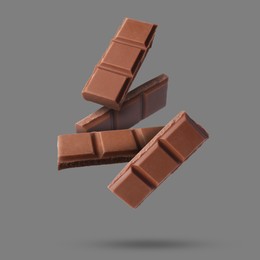 Image of Pieces of sweet chocolate falling on grey background