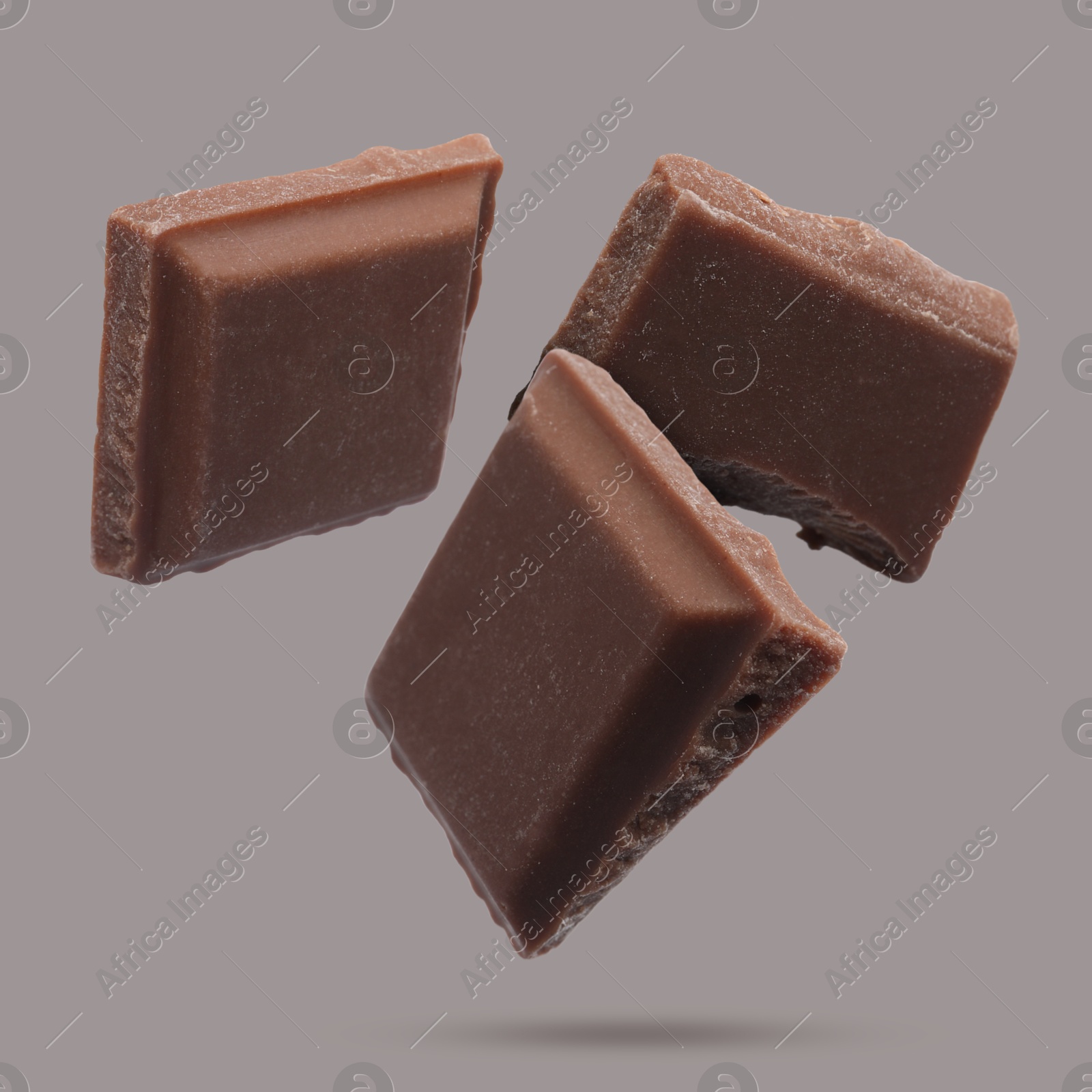 Image of Pieces of sweet chocolate falling on grey background