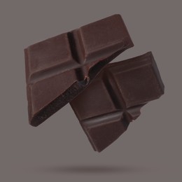 Image of Pieces of sweet chocolate falling on grey background