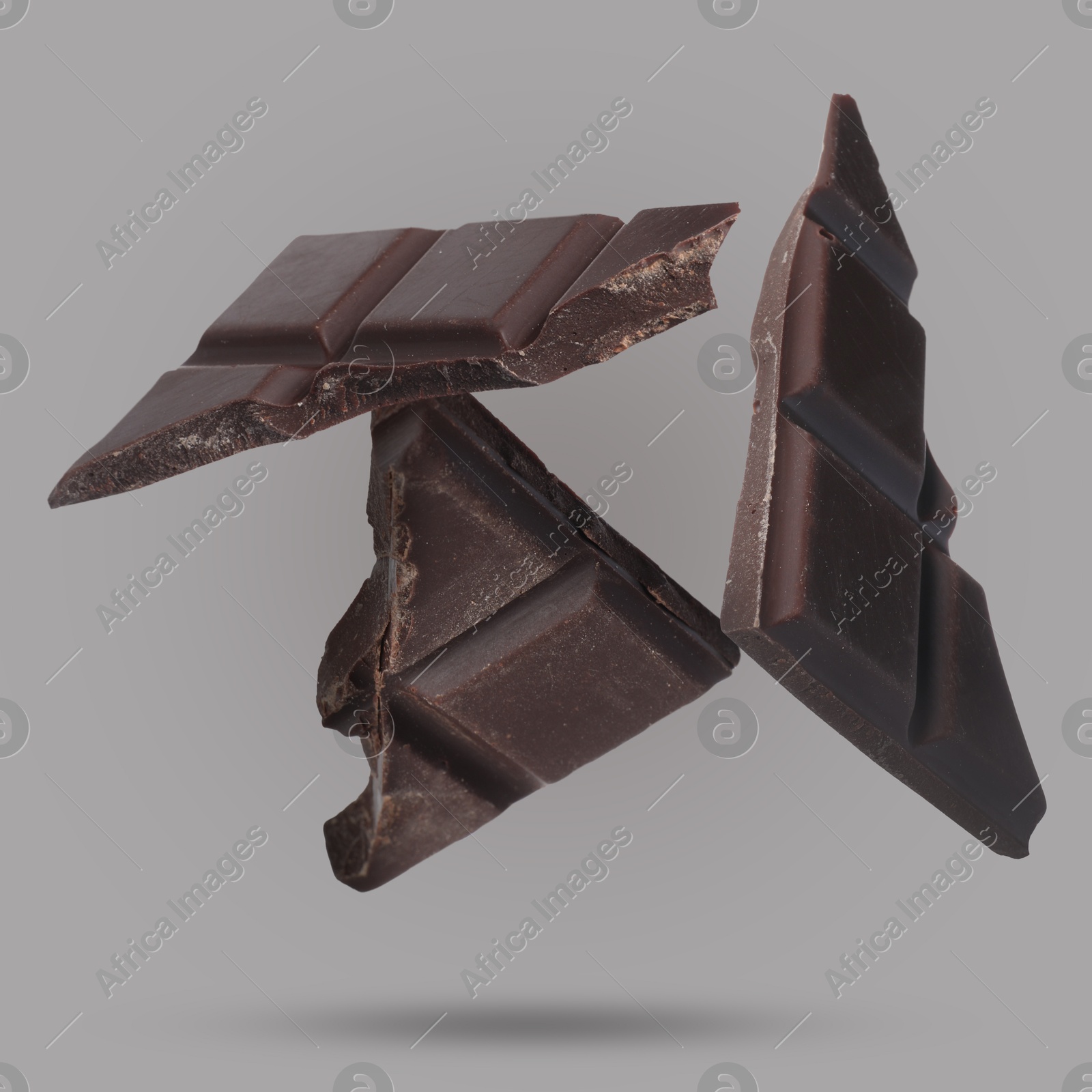 Image of Pieces of sweet chocolate falling on grey background